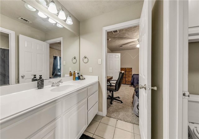 bathroom with tile patterned flooring, a textured ceiling, vanity, and ceiling fan