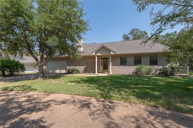 ranch-style house featuring a garage and a front lawn