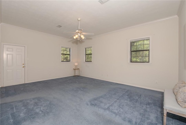 carpeted spare room with a wealth of natural light, ceiling fan, and ornamental molding