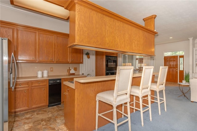 kitchen featuring a kitchen bar, black appliances, and ornamental molding