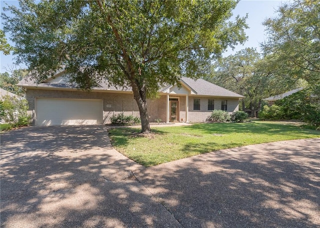 ranch-style home featuring a front lawn and a garage