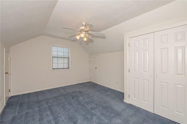 additional living space featuring ceiling fan, lofted ceiling, and dark colored carpet