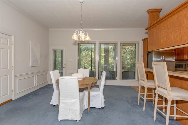 dining area with dark colored carpet, crown molding, and a notable chandelier