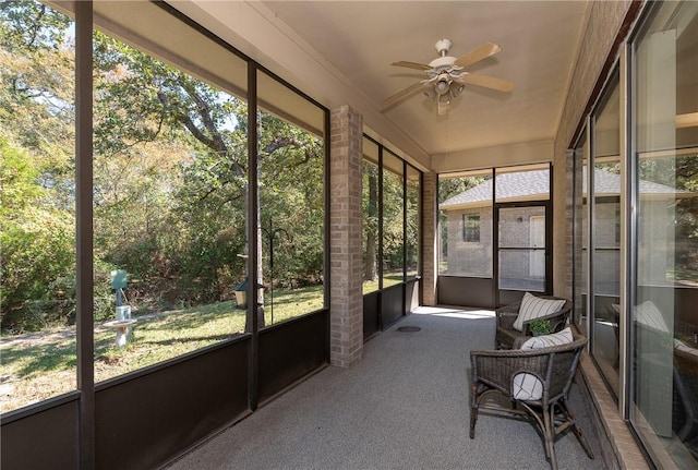 unfurnished sunroom with ceiling fan