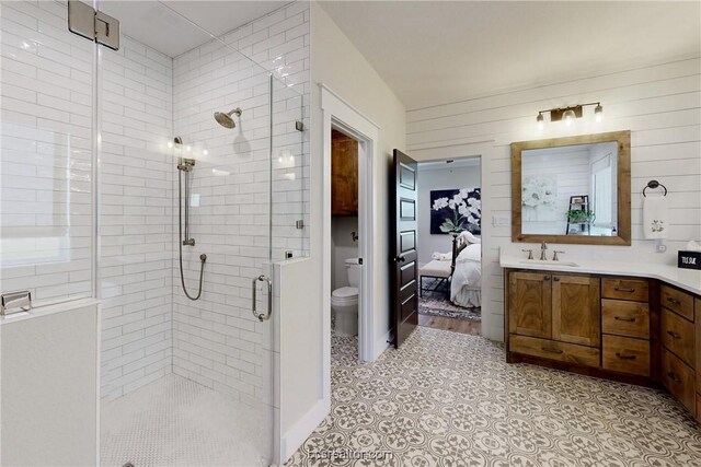 3504 Abingdon Cv, Bryan, TX 77808 - bathroom with toilet, wood walls, an enclosed shower, and vanity