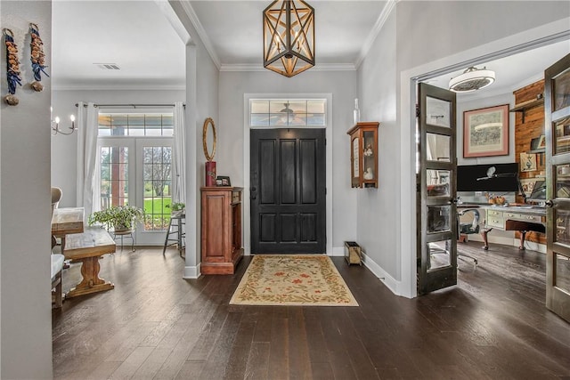 foyer entrance featuring visible vents, baseboards, ornamental molding, and dark wood-style flooring