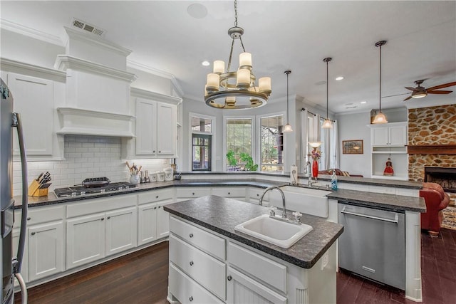 kitchen with visible vents, a kitchen island with sink, a sink, dark wood finished floors, and appliances with stainless steel finishes