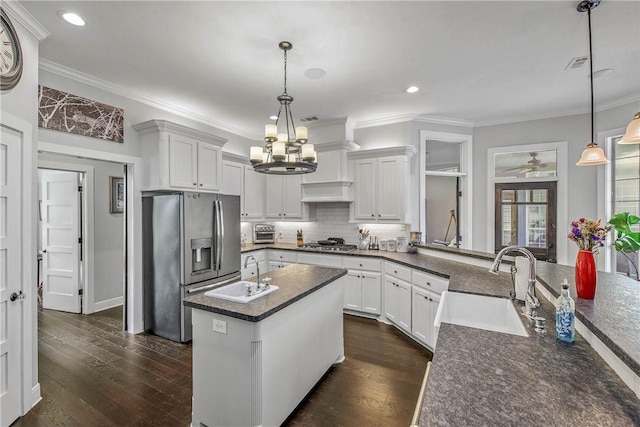 kitchen featuring dark wood-style floors, backsplash, stainless steel appliances, and a sink