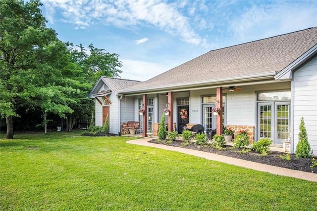 ranch-style home featuring a front yard and roof with shingles