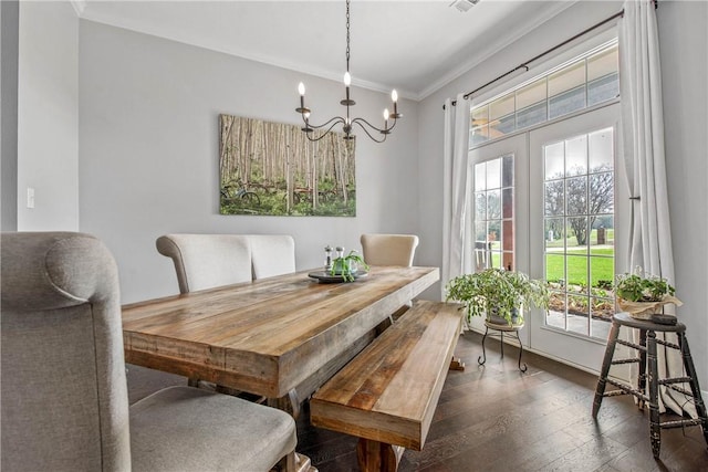 dining room featuring a notable chandelier, dark wood finished floors, and crown molding