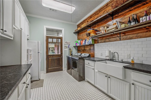 kitchen with visible vents, ornamental molding, open shelves, washer and dryer, and freestanding refrigerator