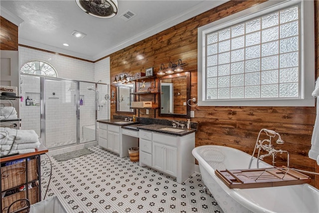 bathroom featuring visible vents, double vanity, a stall shower, a freestanding bath, and a sink