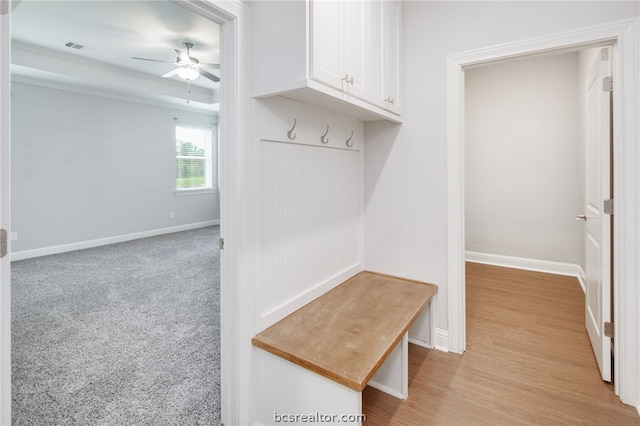 mudroom with a ceiling fan, light colored carpet, visible vents, and baseboards