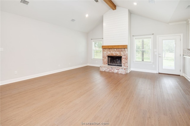 unfurnished living room with beam ceiling, light wood-type flooring, a fireplace, and high vaulted ceiling