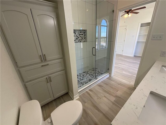 15933 Goliad Loop, Temple, TX 76502 - full bathroom featuring toilet, a shower stall, ceiling fan, and wood finished floors