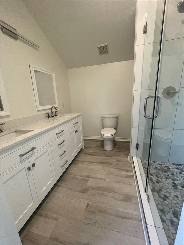 15933 Goliad Loop, Temple, TX 76502 - bathroom with lofted ceiling, toilet, a shower stall, double vanity, and baseboards