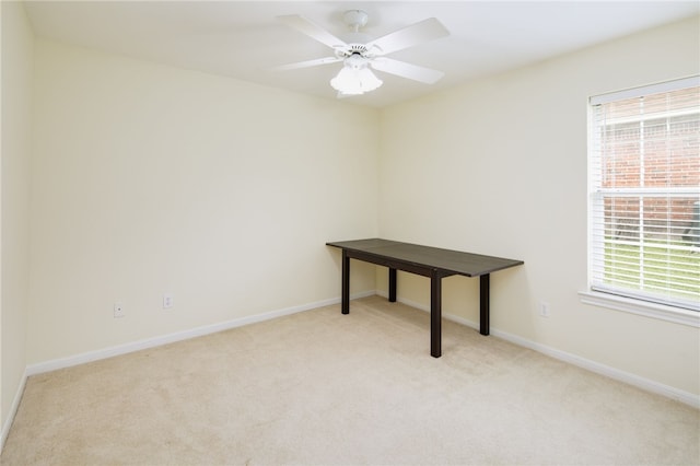 carpeted empty room featuring baseboards and ceiling fan