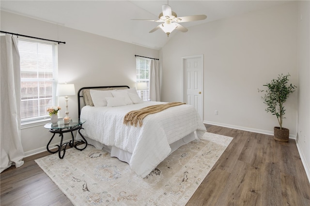 bedroom with baseboards, ceiling fan, wood finished floors, and lofted ceiling