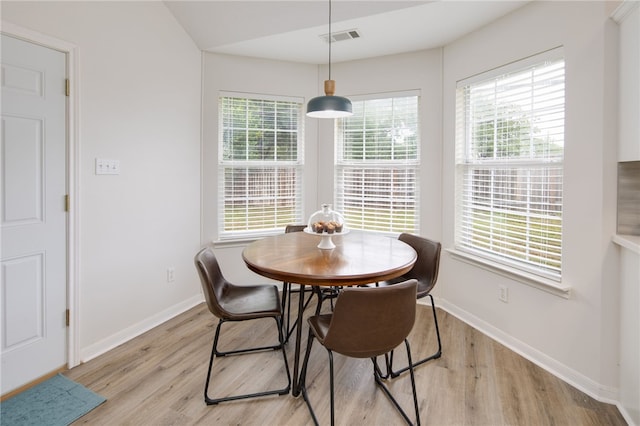 dining area with visible vents, light wood finished floors, and baseboards