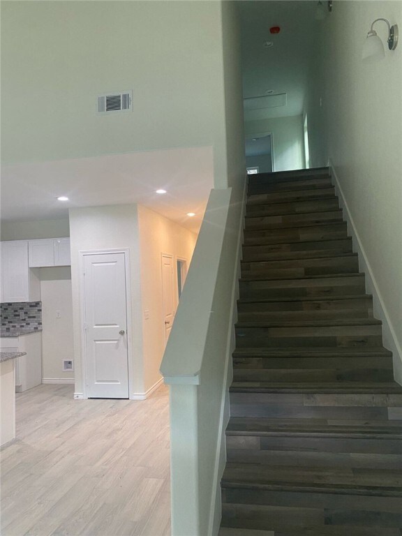 stairs featuring hardwood / wood-style flooring