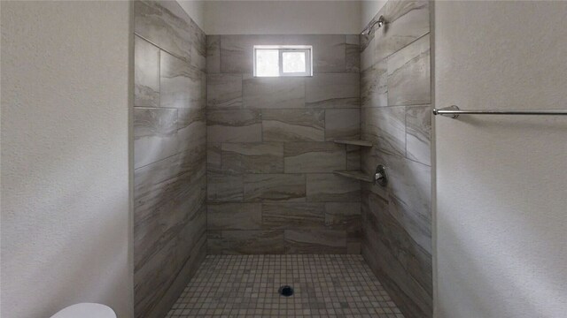 bathroom featuring toilet and tiled shower