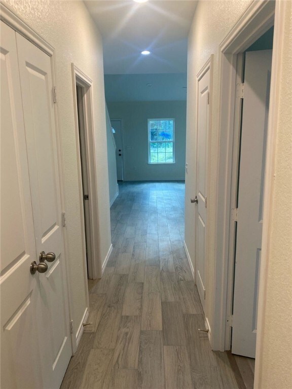 hallway with hardwood / wood-style flooring