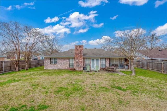 back of house featuring a yard, a patio area, and french doors