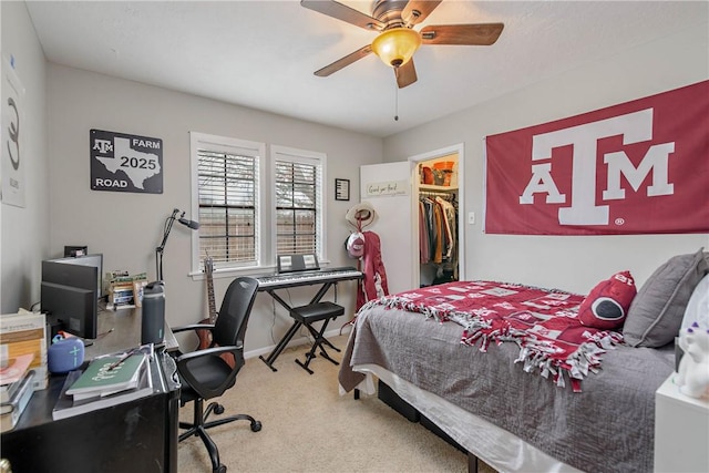 carpeted bedroom featuring a walk in closet, ceiling fan, and a closet