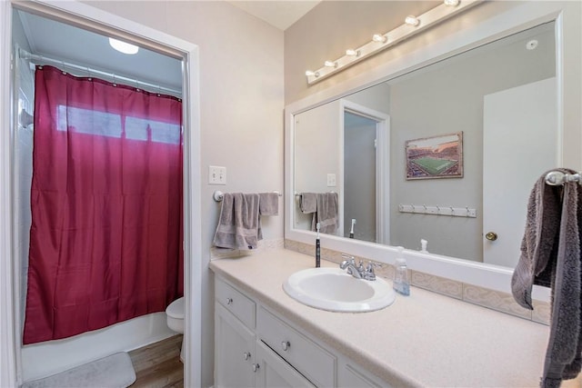 bathroom with vanity, hardwood / wood-style floors, toilet, and walk in shower