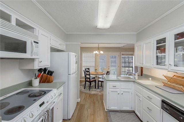 kitchen featuring hanging light fixtures, white cabinetry, white appliances, and light hardwood / wood-style floors