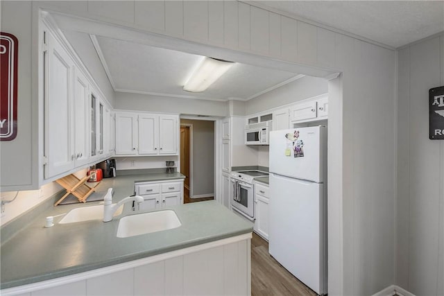 kitchen with white cabinetry, sink, dark hardwood / wood-style flooring, kitchen peninsula, and white appliances