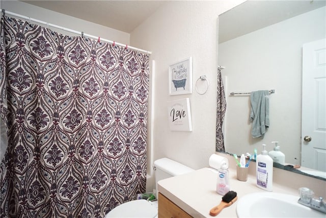 bathroom featuring a shower with shower curtain, vanity, and toilet