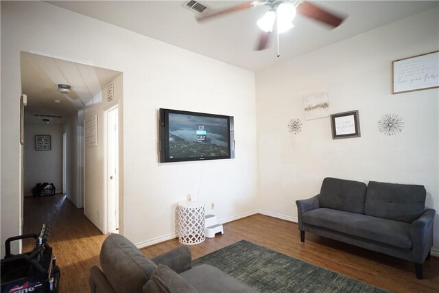 living area featuring a ceiling fan, baseboards, visible vents, and wood finished floors