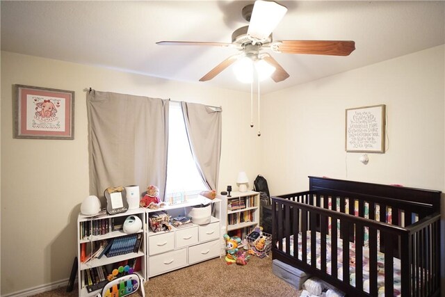 bedroom with ceiling fan, carpet floors, and a nursery area