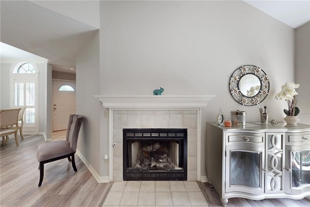3900 Puffin Way, College Station, TX 77845 - living room featuring wood finished floors, a tiled fireplace, and baseboards