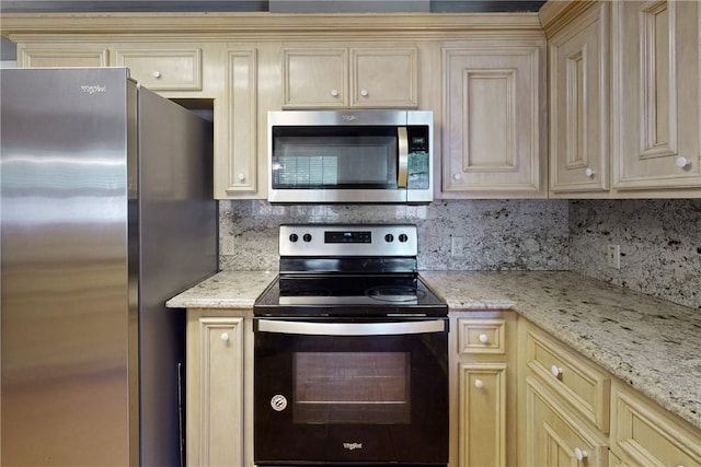 3900 Puffin Way, College Station, TX 77845 - kitchen with stainless steel appliances, cream cabinetry, decorative backsplash, and light stone countertops