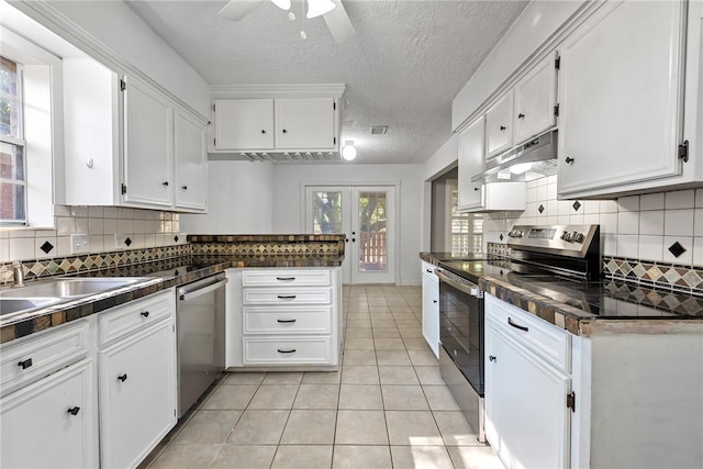 kitchen with white cabinets, light tile patterned floors, a textured ceiling, and appliances with stainless steel finishes