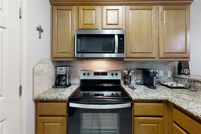 130 Forest Dr, College Station, TX 77840 - kitchen featuring stainless steel microwave, electric range, decorative backsplash, and light stone countertops