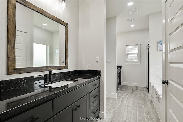 bathroom featuring a shower, vanity, and hardwood / wood-style flooring