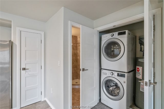 laundry room featuring water heater, stacked washer / dryer, and light tile patterned flooring