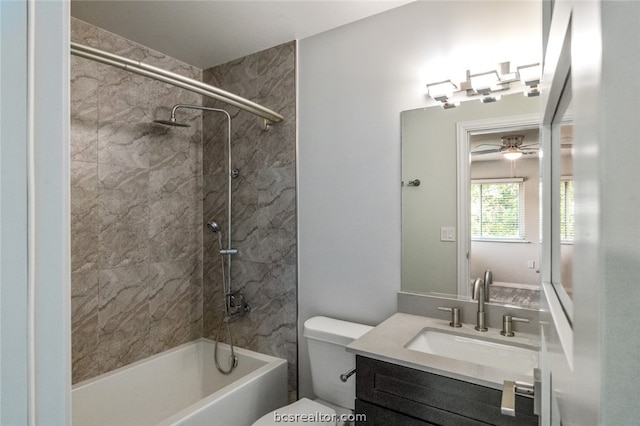 full bathroom featuring vanity, ceiling fan, toilet, and tiled shower / bath combo