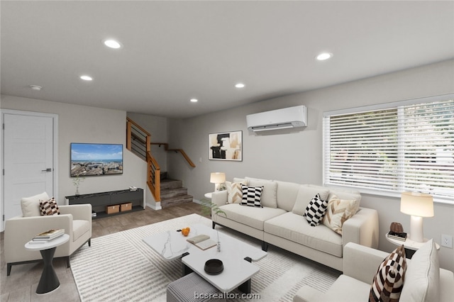 living room with a wall mounted air conditioner and light hardwood / wood-style floors