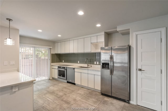 kitchen with hanging light fixtures, sink, white cabinets, and stainless steel appliances