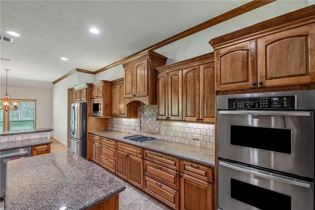 4662 Hidden Springs Way, College Station, TX 77845 - kitchen featuring appliances with stainless steel finishes, decorative backsplash, a chandelier, brown cabinets, and crown molding