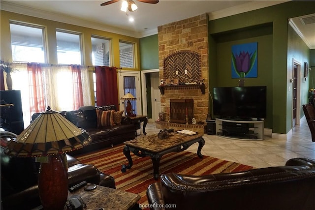 living room with ceiling fan, ornamental molding, a fireplace, and light tile patterned floors