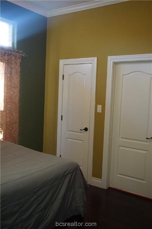 bedroom featuring dark hardwood / wood-style floors and ornamental molding