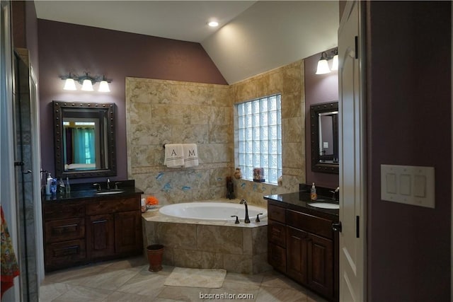 bathroom with tile patterned floors, tiled bath, vanity, and lofted ceiling