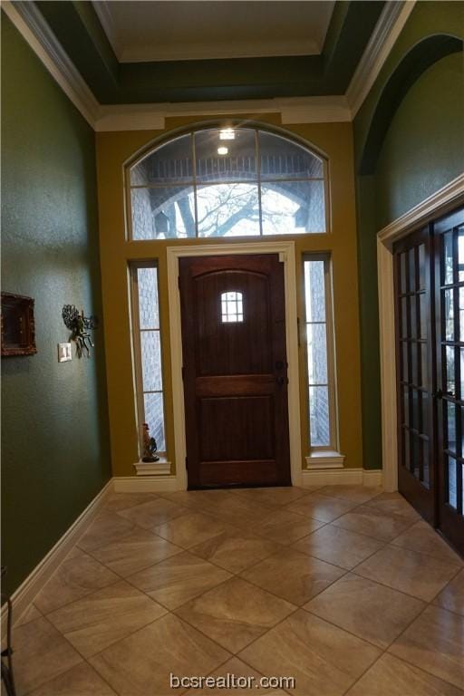 foyer featuring crown molding and french doors