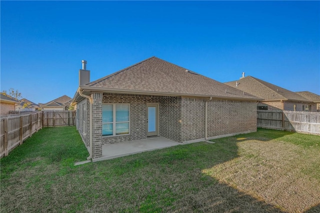 back of house with a patio area and a yard