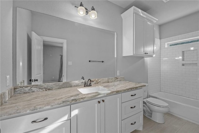 full bathroom with vanity, tiled shower / bath combo, and toilet